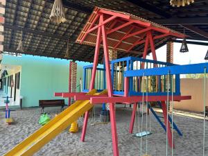 a playground in a building with a play structure at Pousada Bellissima Italia in Luis Correia
