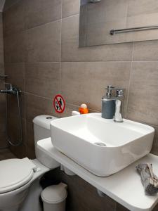a bathroom with a white sink and a toilet at ANGIRA - Koroni Apartments in Koroni +159 photos