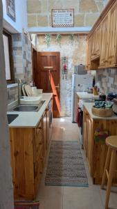 a large kitchen with wooden cabinets and a sink at Historical Apartment in Bormla in Cospicua