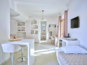 a white living room with a white table and chairs at Rocaia Mini Suites Naousa in Naousa
