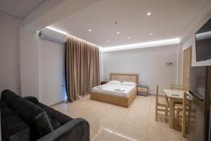 a bedroom with a bed and a table and a couch at Villa HENA in Sarandë