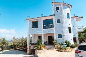 a large white building with a car parked in front at Villa HENA in Sarandë