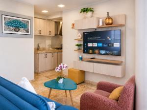 a living room with a blue couch and a tv at Chanka Suites in Talavera