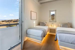 two beds in a room with a window at Villa RED VENUS in Kalafatis +46 photos