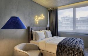 Ein Schlafzimmer mit einem Bett, einem Stuhl und einem Schild mit der Aufschrift „Wahrheit“. in der Unterkunft ONOMA Hotel in Thessaloniki