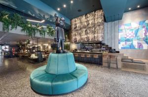 Eine Statue einer Frau, die in einem Restaurant auf einem blauen Stuhl sitzt in der Unterkunft ONOMA Hotel in Thessaloniki