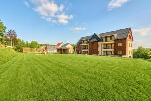 a large grassy field in front of a building at George 01 Kovářská by Mountain ways in Kovářská