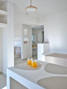two glasses of orange juice on a table in a bedroom at Rocaia Mini Suites Naousa in Naousa