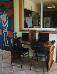 a desk with two chairs and a laptop on it at Take it Easy Hostel in Florianópolis +26 photos