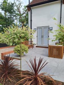 a patio with a bench and a house at Woodpeckers Annexe in Gosfield in Gosfield