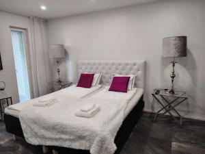 a bedroom with a large bed with two pink pillows at Anne House in Raisio