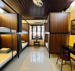 a room with three bunk beds and a desk at Old Lane Homestay in Hoi An