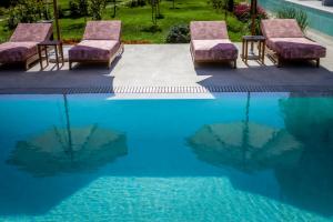 a group of chairs sitting next to a swimming pool at JADORE Deluxe Studios in Sunny Beach +34 photos