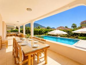 a dining room with a table and a swimming pool at Villa Kubra in Dalyan