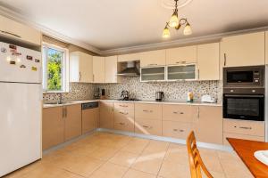 a kitchen with white appliances and a wooden table at Villa Kubra in Dalyan