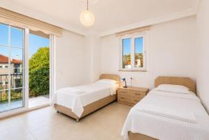 two beds in a white room with windows at Villa Kubra in Dalyan +18 photos