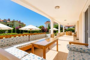 a patio with couches and a table and chairs at Villa Kubra in Dalyan