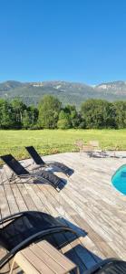 a deck with lounge chairs and a swimming pool at La Maison Bleue - Escale en Ubaye in Saint-Pons