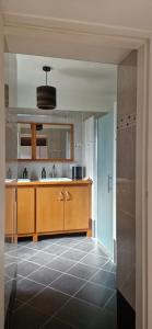 a kitchen with wooden cabinets and a tile floor at La Maison Bleue - Escale en Ubaye in Saint-Pons