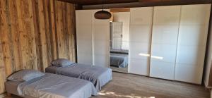 a bedroom with two beds and a large closet at La Maison Bleue - Escale en Ubaye in Saint-Pons