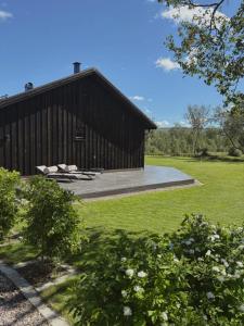 a barn with two chairs in front of it at Forest lodge in Norskholmen