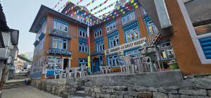 a building with chairs sitting in front of it at Shangri-la Guest House in Phakding