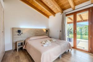 a bedroom with a bed and a large window at S'istella suite in Olbia