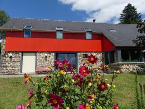 a red house with flowers in front of it at REVES DE BAIE - Chambre d'hôtes COSY avec table BIO et MASSAGES - Vue panoramique exceptionnelle in Tirepied