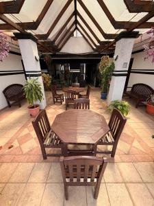 eine Terrasse mit einem Holztisch und Stühlen in der Unterkunft City Hotel in Cochabamba + 39 Fotos