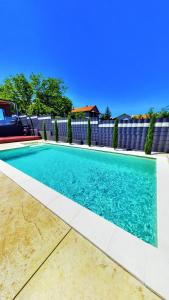 a swimming pool with blue water in a yard at Elysium Garden in Belgrade