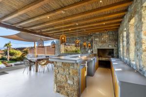 an open kitchen with a stone wall at Villa RED VENUS in Kalafatis