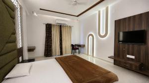 a hotel room with a bed and a television at Star resort in Bhusāwal