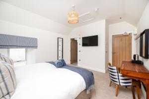 a bedroom with a white bed and a desk at Shore Hotel in Balintore