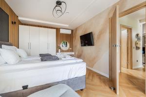 a bedroom with a large bed and a tv at Elite House Gold Apartment in Leányfalu