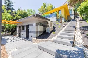 a house with concrete steps in front of a building at Elite House Gold Apartment in Leányfalu