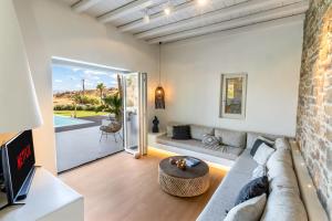 a living room with a couch and a table at Villa RED VENUS in Kalafatis