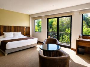 a bedroom with a bed and a desk and a table at Hotel Villa del Carmen in Arequipa
