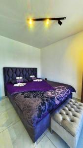 a bedroom with a purple bed and a couch at Elysium Garden in Belgrade +26 photos