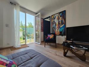 a living room with a couch and a large screen tv at Maison chic & chill in Saint-Brieuc