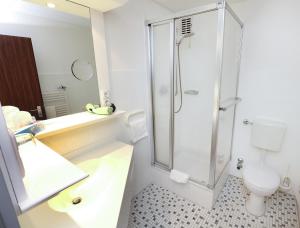 La salle de bains est pourvue d'une douche, d'un lavabo et de toilettes. dans l'établissement Hotel Kröger, à Ennigerloh