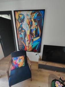 a living room with a chair and a painting on the wall at Maison chic & chill in Saint-Brieuc