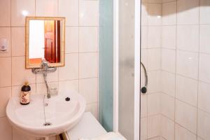 a white bathroom with a sink and a mirror at Penzion Trstená in Trstená +16 photos