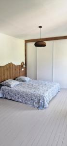 a bedroom with a bed with a blue comforter at La Maison Bleue - Escale en Ubaye in Saint-Pons +6 photos