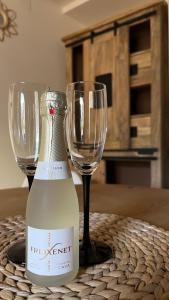 a bottle of wine and two wine glasses on a table at Las Casitas de Martín in Candeleda