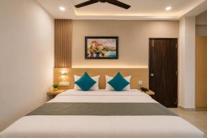a bedroom with a large bed with blue pillows at Hotel Elite kukatpally Near Nexus Mall in Hyderabad