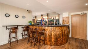 a wooden bar with stools in a room at Shore Hotel in Balintore