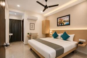 a bedroom with a large bed with a ceiling fan at Hotel Elite kukatpally Near Nexus Mall in Hyderabad