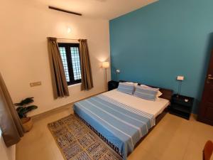 a bedroom with a bed and a window at Aurena Stays Varkala in Varkala