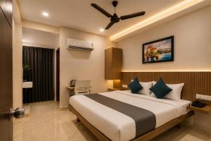 a bedroom with a large bed with a ceiling fan at Hotel Elite kukatpally Near Nexus Mall in Hyderabad +18 photos