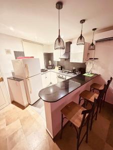 a kitchen with white appliances and a table and chairs at Charmant duplex proche mer à Carthage in Carthage +4 photos